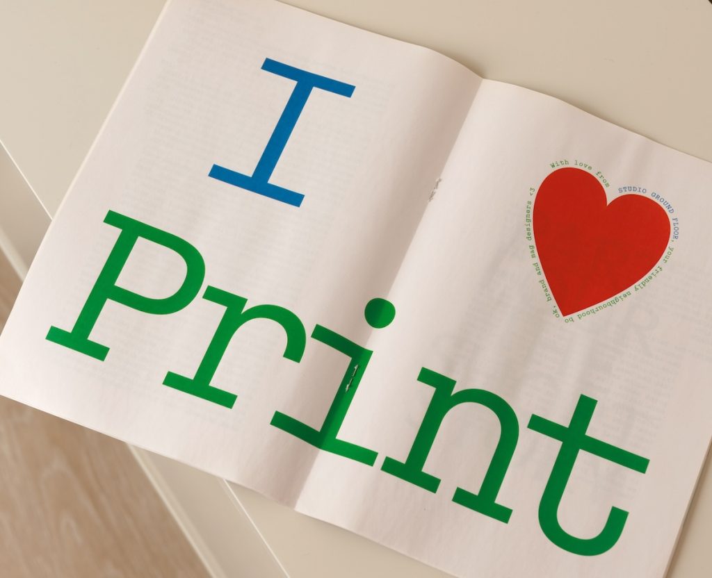 Inside spread of mini newspaper with “I ❤️ Print” in large text.